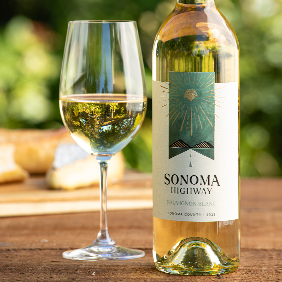 Photo of Sonoma Highway Sauvignon blanc on an outdoor table with a poured glass of wine and cheese platter