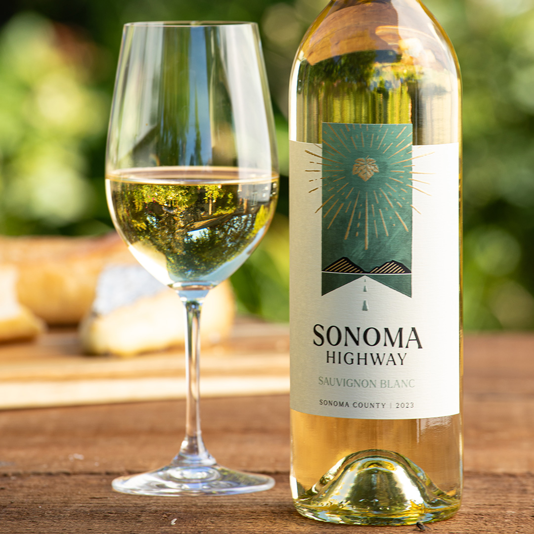 Photo of Sonoma Highway Sauvignon Blanc bottle on a table with poured glass and cheese tray